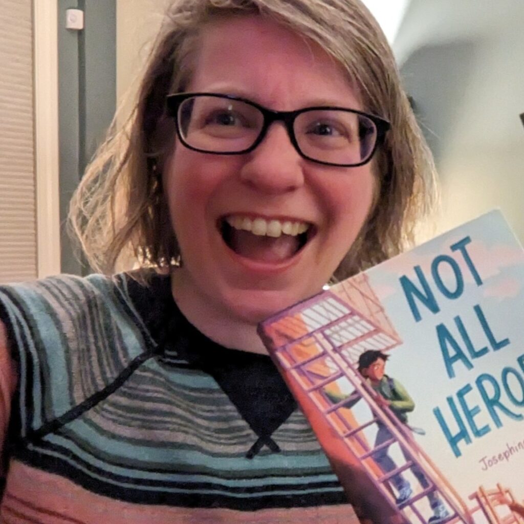 Josephine holding a copy of the Not All Heroes paperback